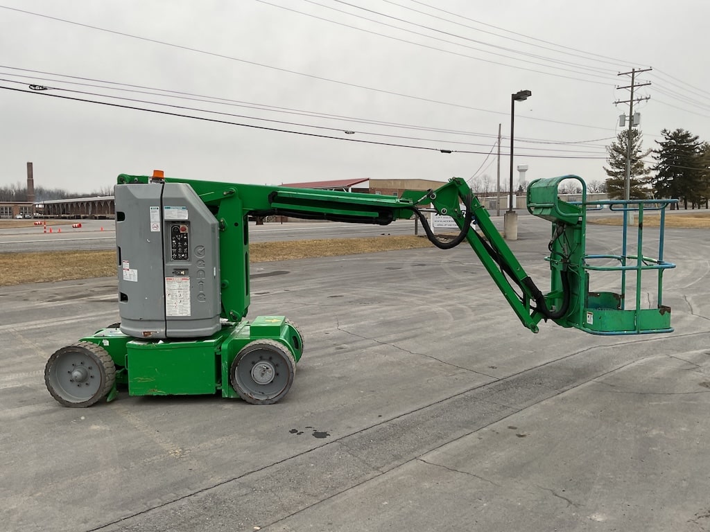 Green and Grey Genie Lift sitting in parking lot